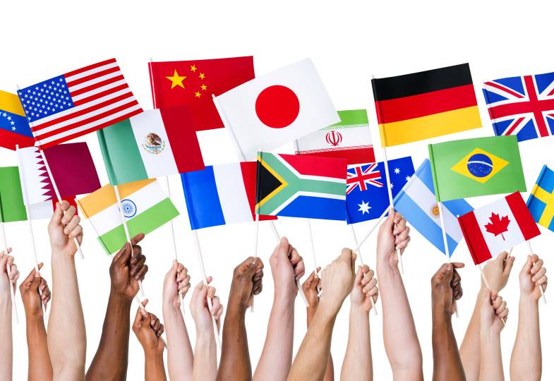 A bunch of hands holding flags of different countries.