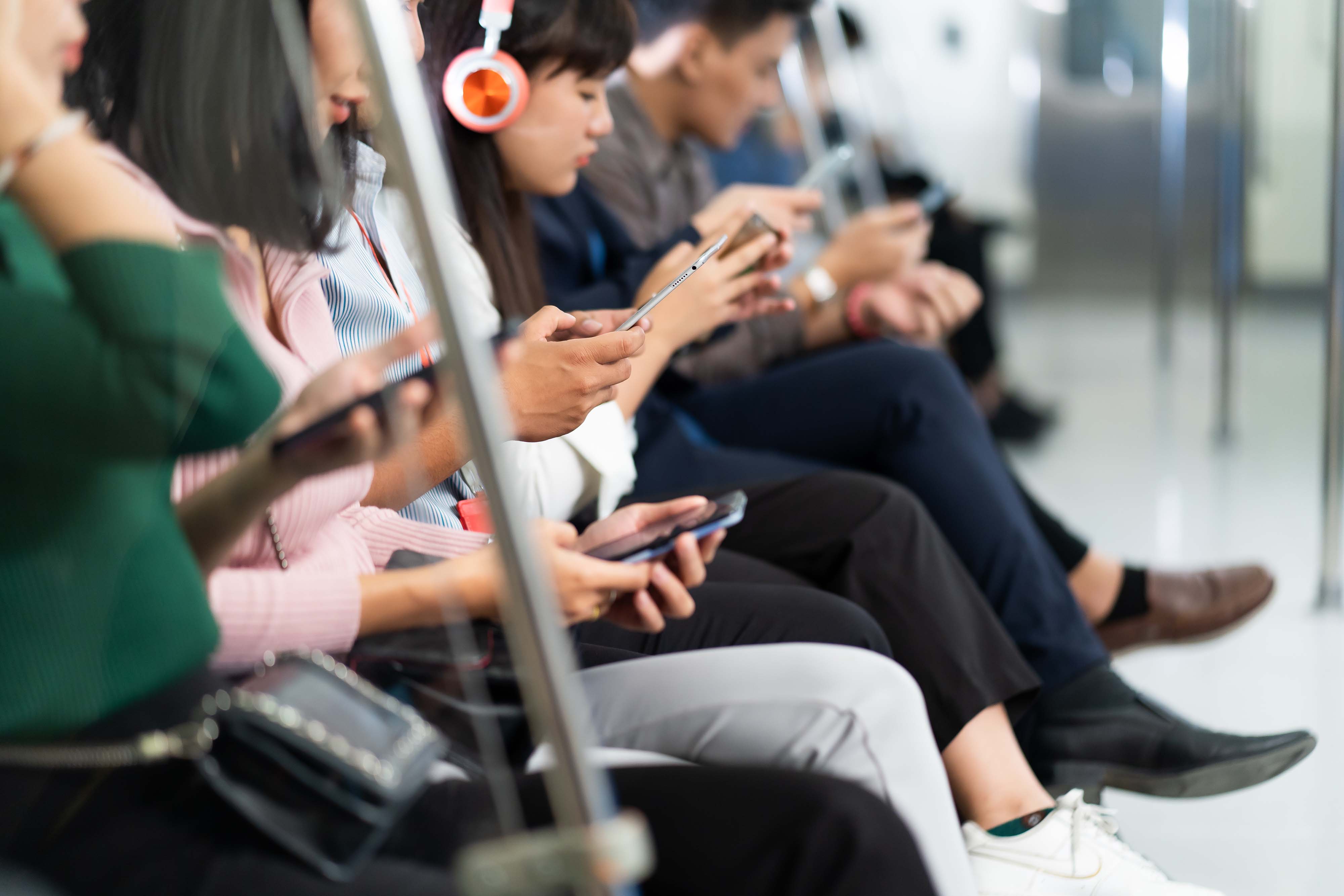 People using phones on a bus